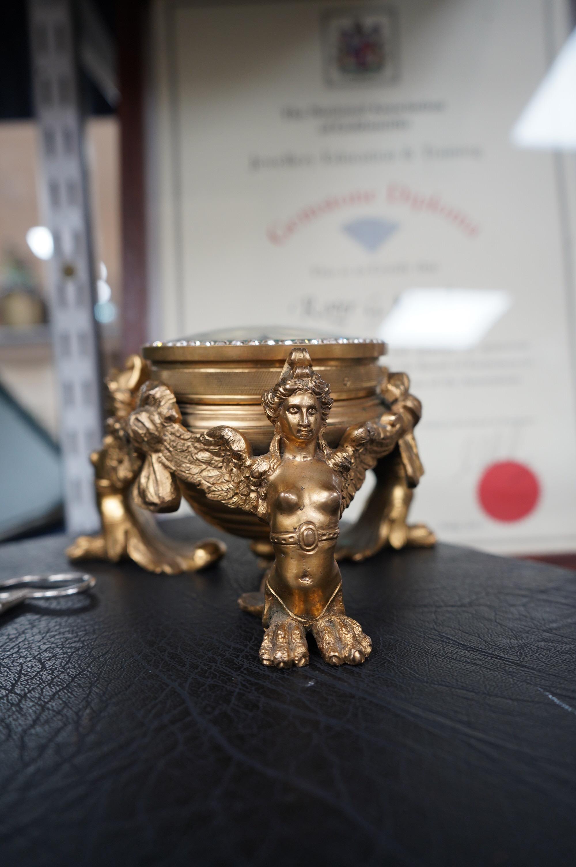 A 19th century French ormolu table timepiece decorated with paste jewelling edged dial and three classical figures, widest point 15cm. Condition - good, not been checked as working